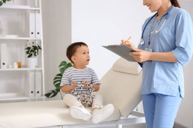 Kadın çocuk doktoru ve klinikteki kanepede oturan moleküler modeli olan sevimli bir çocuk.