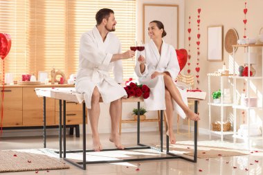 Sevgililer Günü 'nde spa salonunda şarap içen genç bir çift.