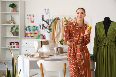 Atölyede iplik makaralı kadın terzi