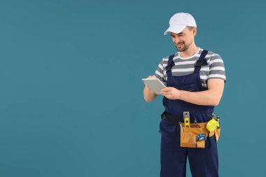 Mavi arkaplanda tablet bilgisayar kullanan erkek teknisyen
