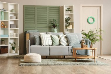 Konforlu kanepe, sehpa ve oturma odasının iç tarafındaki raf üniteleri.