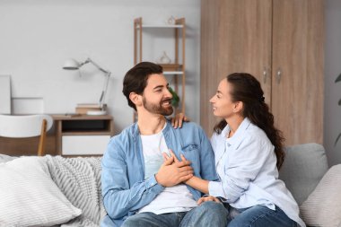 Evdeki kanepede oturan evli çift.