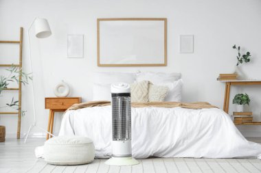 Yatak odasındaki halının üstünde elektrikli ısıtıcı.