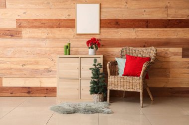 Oturma odasının içinde koltuk, köknar ağacı ve klozette Noel bitkisi var.