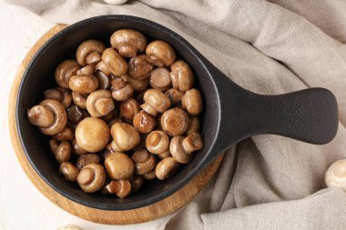 Kızarmış mantarlı tava beyaz arka planda.