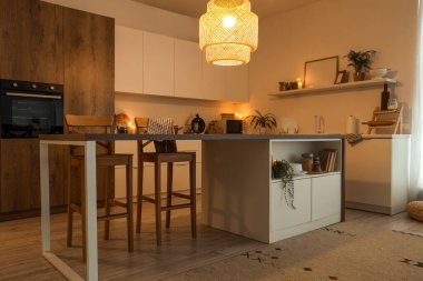 Akşam vakti mutfak masası, tezgah ve parlayan lamba.