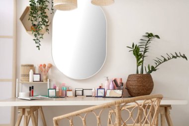 Açık soyunma odasındaki masada bitki bulunan farklı makyaj ürünleri.