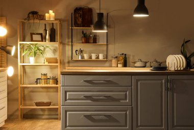 Mutfağın içinde tezgahlar, raflar ve gece lambaları var.