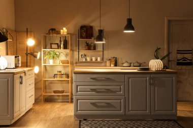 Mutfağın içinde tezgahlar, raflar ve gece lambaları var.