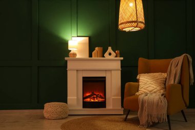 Geceleri şöminesi, koltuğu ve parlayan lambaları olan karanlık oturma odasının içinde.