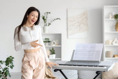 Evde sentezleyicili genç bir kadın