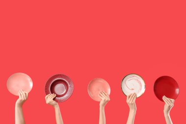 Kırmızı arka planda farklı plakalı kadın elleri