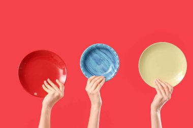 Kırmızı arka planda farklı plakalı kadın elleri