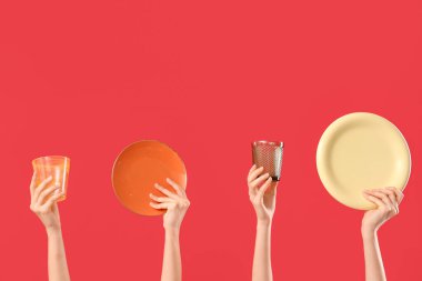 Kırmızı arka planda tabak ve gözlüklü kadın elleri