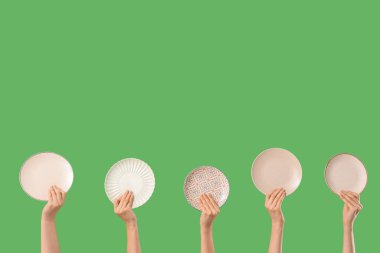 Yeşil arka planda farklı plakalı kadın elleri