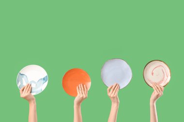 Yeşil arka planda farklı plakalar taşıyan genç kadınlar