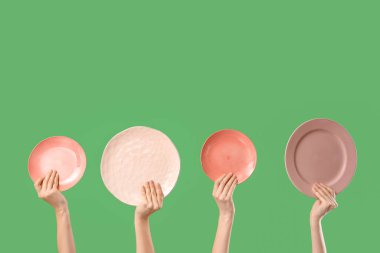 Yeşil arka planda farklı plakalar taşıyan genç kadınlar