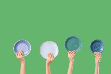 Yeşil arka planda farklı plakalı kadın elleri