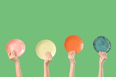 Yeşil arka planda farklı plakalar taşıyan genç kadınlar