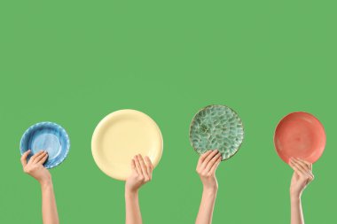 Yeşil arka planda farklı plakalar taşıyan genç kadınlar