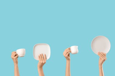 Tabaklı kadın elleri, mavi arka planda sürahi ve kupa