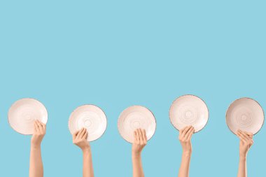 Mavi arka planda beyaz plakalı kadın elleri