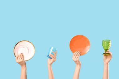 Mavi arka planda tabak ve gözlüklü kadın elleri