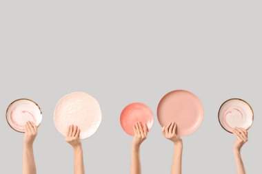 Beyaz arka planda farklı plakalı kadın elleri