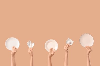 Plakalı kadın elleri, seramik kepçeler ve bej arka planda turunçgil sıkacağı.