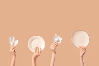 Plakalı kadın elleri, seramik kepçeler ve bej arka planda turunçgil sıkacağı.