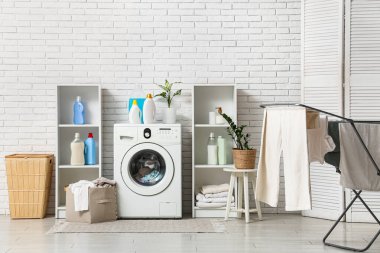 Çamaşır makinesi, deterjan ve kurutma makinesi olan bir çamaşır odası.