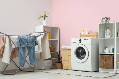 Çamaşır makinesi, kurutma makinesi ve raf üniteleri olan modern çamaşır odasının içi.