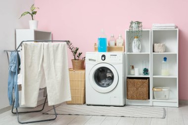 Çamaşır makinesi, kurutma makinesi ve raf üniteleri olan modern çamaşır odasının içi.