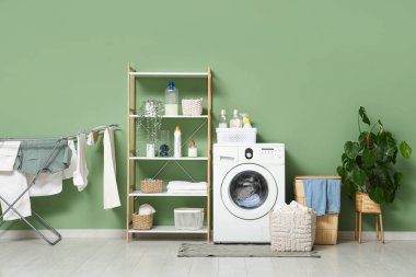 Çamaşır makinesi, sepet ve kurutuculu modern çamaşır odasının içi.