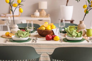 Yemek odasında bir sürü taze turta ve limon ağacı dallarıyla süslenmiş şık bir masa.