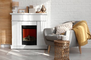 İçinde şöminesi, koltuğu ve hasır sehpası olan modern oturma odası.