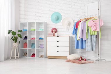 Askısı, çekmecesi ve raf ünitesi olan şık bir soyunma odası.