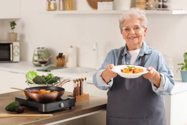 Mutfakta kızarmış makarnası olan son sınıf kadını.
