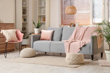 Oturma odasında kanepe, ekose örgü ve sandalye var.