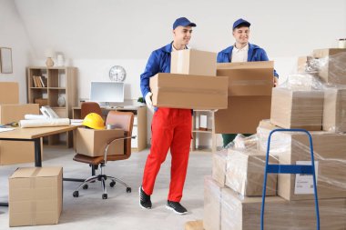 Ofiste kutu taşıyan erkek yükleyiciler.