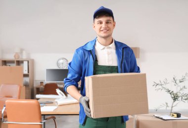 Ofisinde karton kutusu olan bir erkek yükleyici.