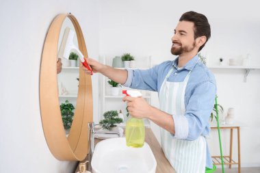 Banyoda aynayı temizleyen yakışıklı adam.