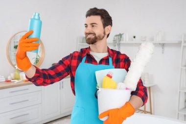 Tuvalette temizlik malzemesi taşıyan erkek hademe.