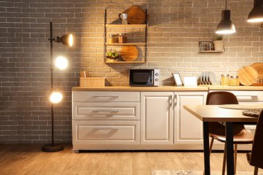 Mutfağın içinde tezgahlar, raflar ve gece lambaları var.