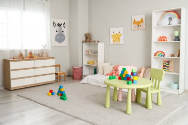 İçinde yatak, raf üniteleri ve oyuncaklar olan çocuk odası.