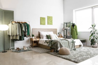 Modern yatak odasının içinde giysi ve mankenlerle dolu raflar.