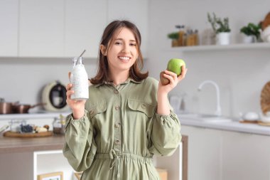 Chia tohumlu yoğurt ve mutfakta meyveli genç bir kadın.