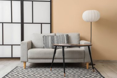 Gri kanepe, lamba ve katlanır perdeli oturma odasının içi.