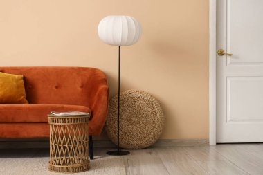 Oturma odasının içinde kırmızı kanepe, lamba ve masa.