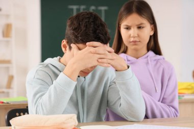 Sınıfta oturan öğrencilerin okul sonuçları yüzünden moralleri bozuk.